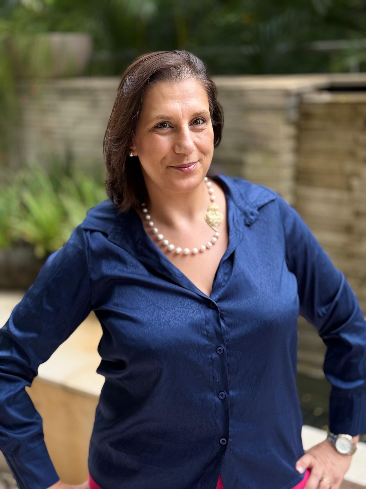 Ágata Castro em pé, transmitindo presença e autoridade profissional